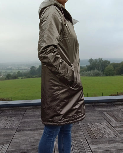 Woman wearing bronze Laura Jo raincoat from Le Petit Placard on terrace with countryside view
