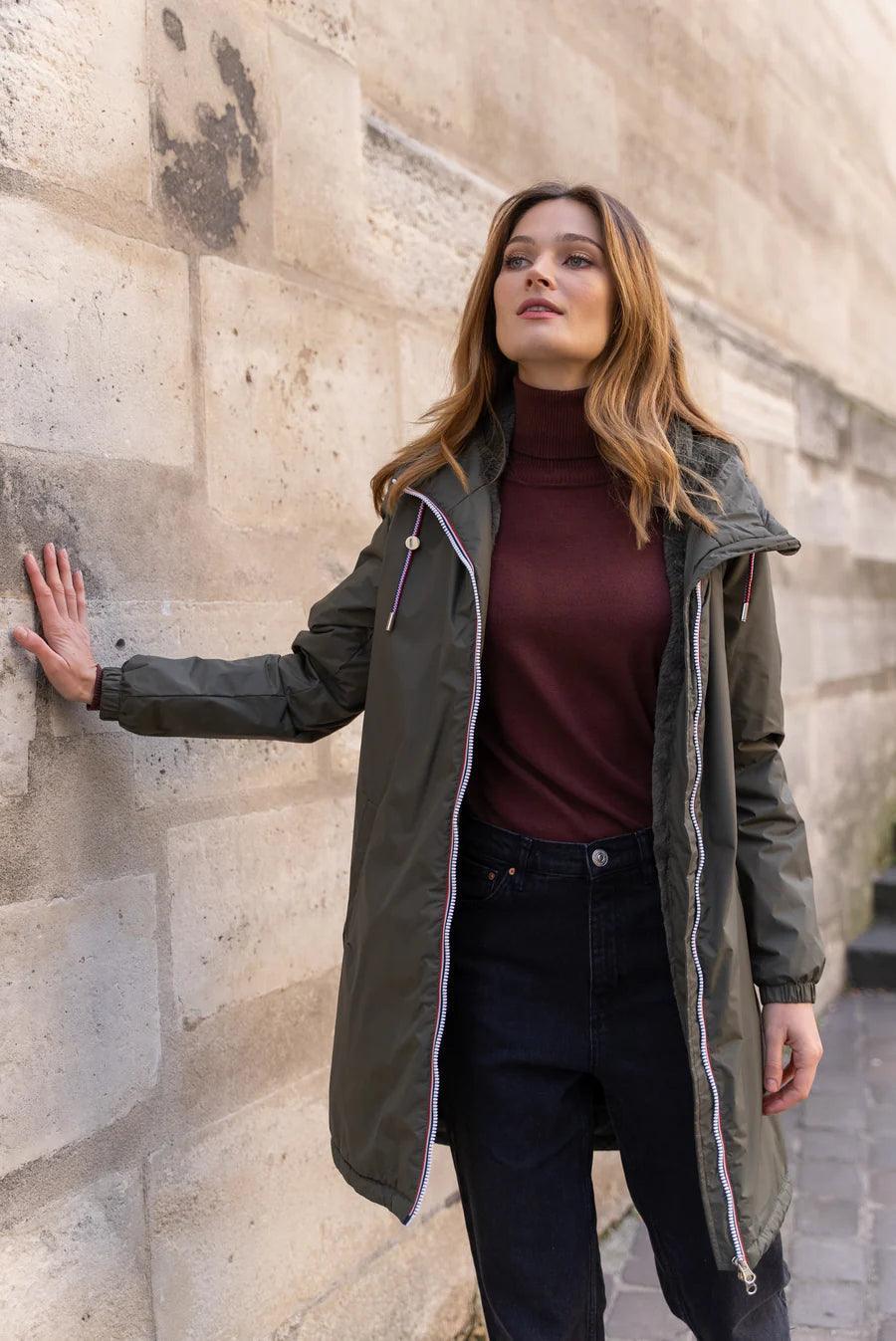 Woman wearing Laura Jo khaki raincoat with tricolor drawstring, outdoor urban scene