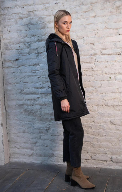Woman modeling black Laura Jo raincoat with faux fur hood and tricolor cord, Le Petit Placard