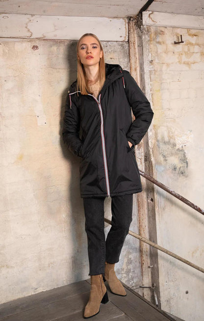 Woman wearing black Laura Jo raincoat with faux fur trim and tricolor cord, Le Petit Placard