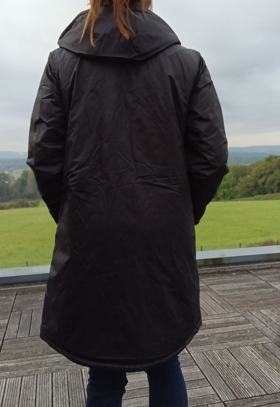 Woman wearing a long black Laura Jo raincoat outdoors, Le Petit Placard fashion