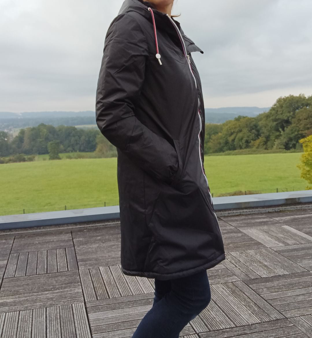 Woman wearing Laura Jo long black raincoat with tricolor drawstring outdoors
