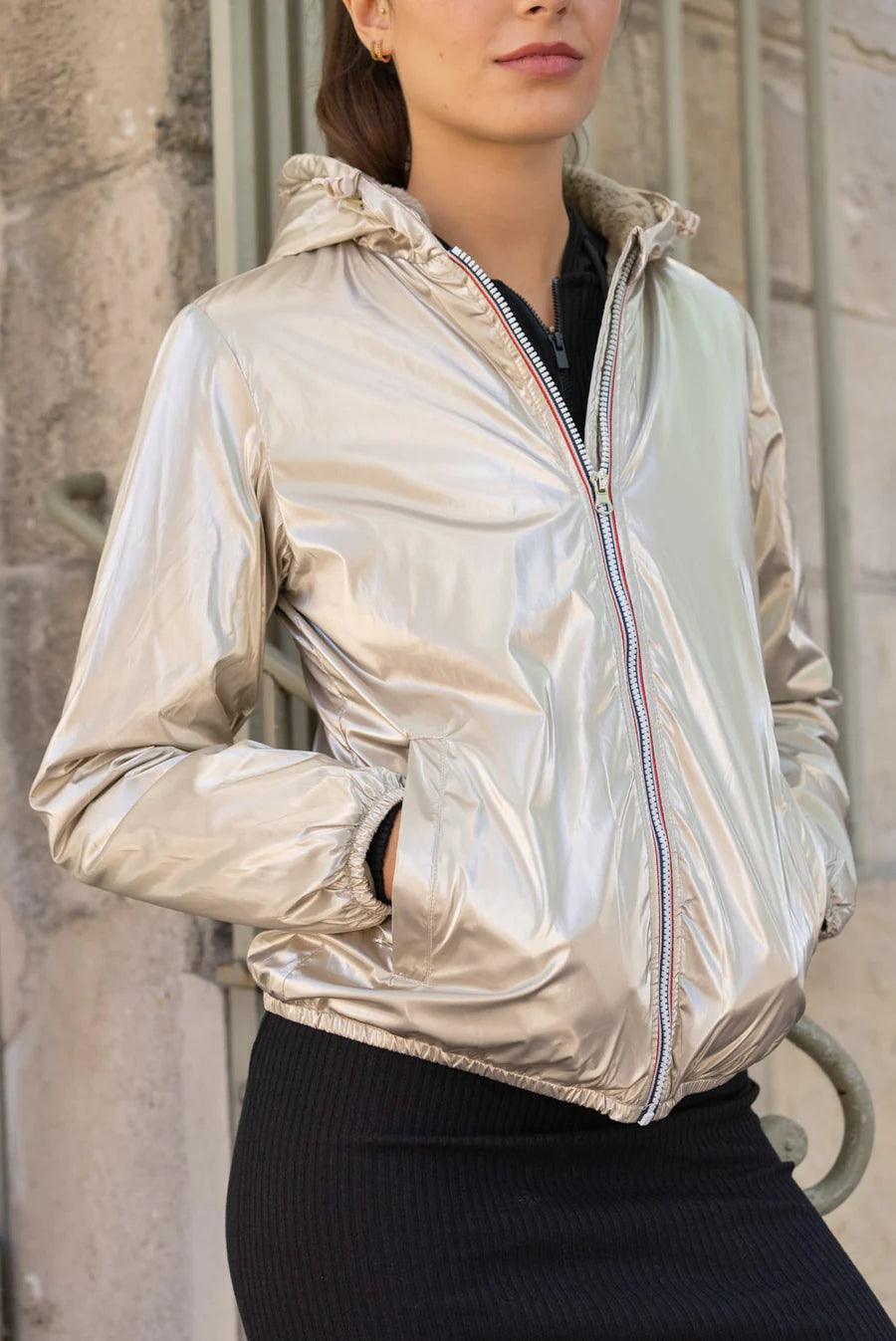 Woman wearing Laura Jo short gold waterproof jacket, hooded, available at Le Petit Placard