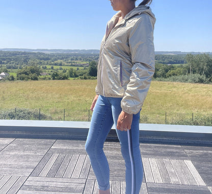Woman in a shiny gold Laura Jo waterproof short jacket and skinny jeans outdoors