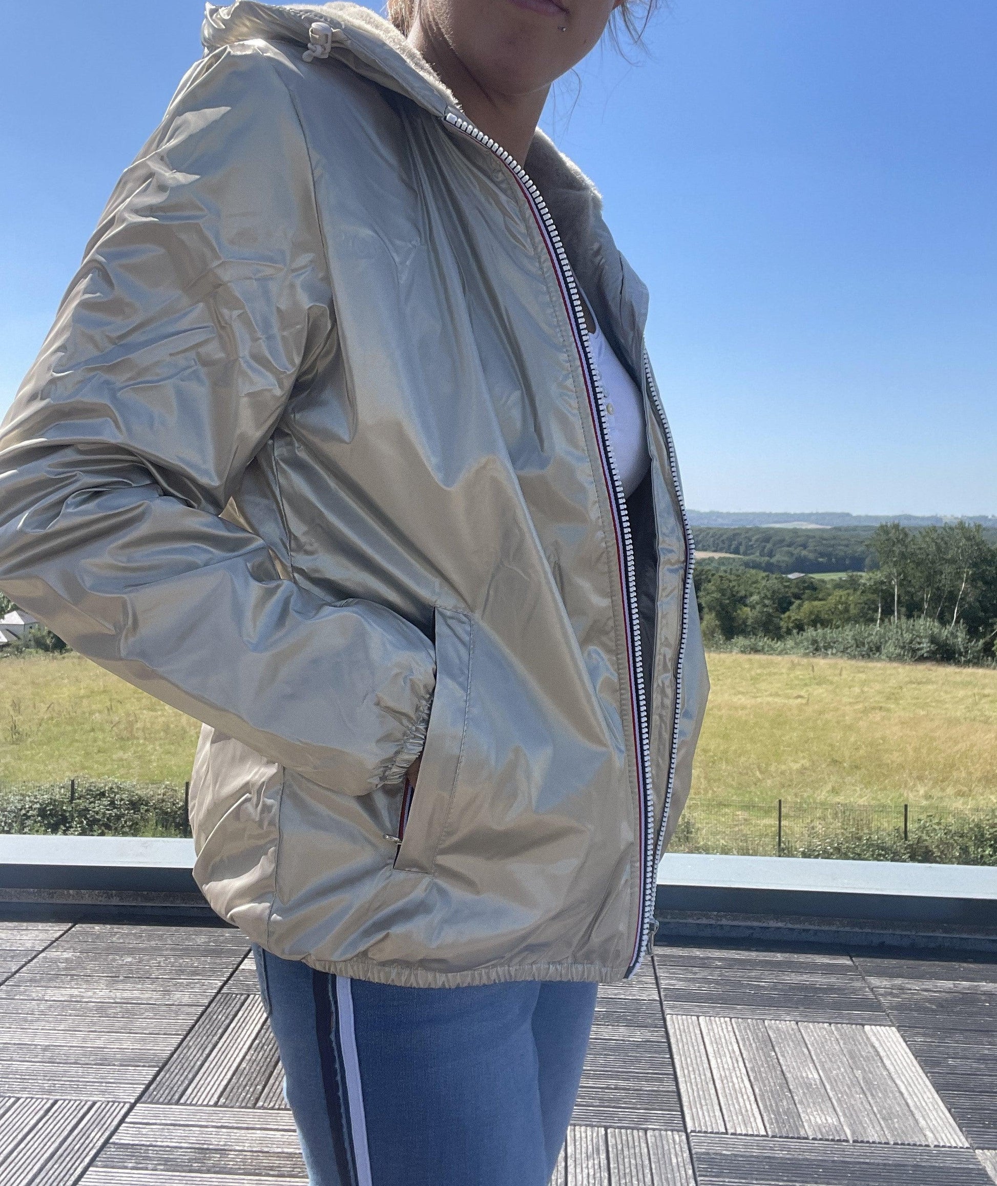 Woman wearing a gold Laura Jo waterproof short coat outdoors, Le Petit Placard fashion.