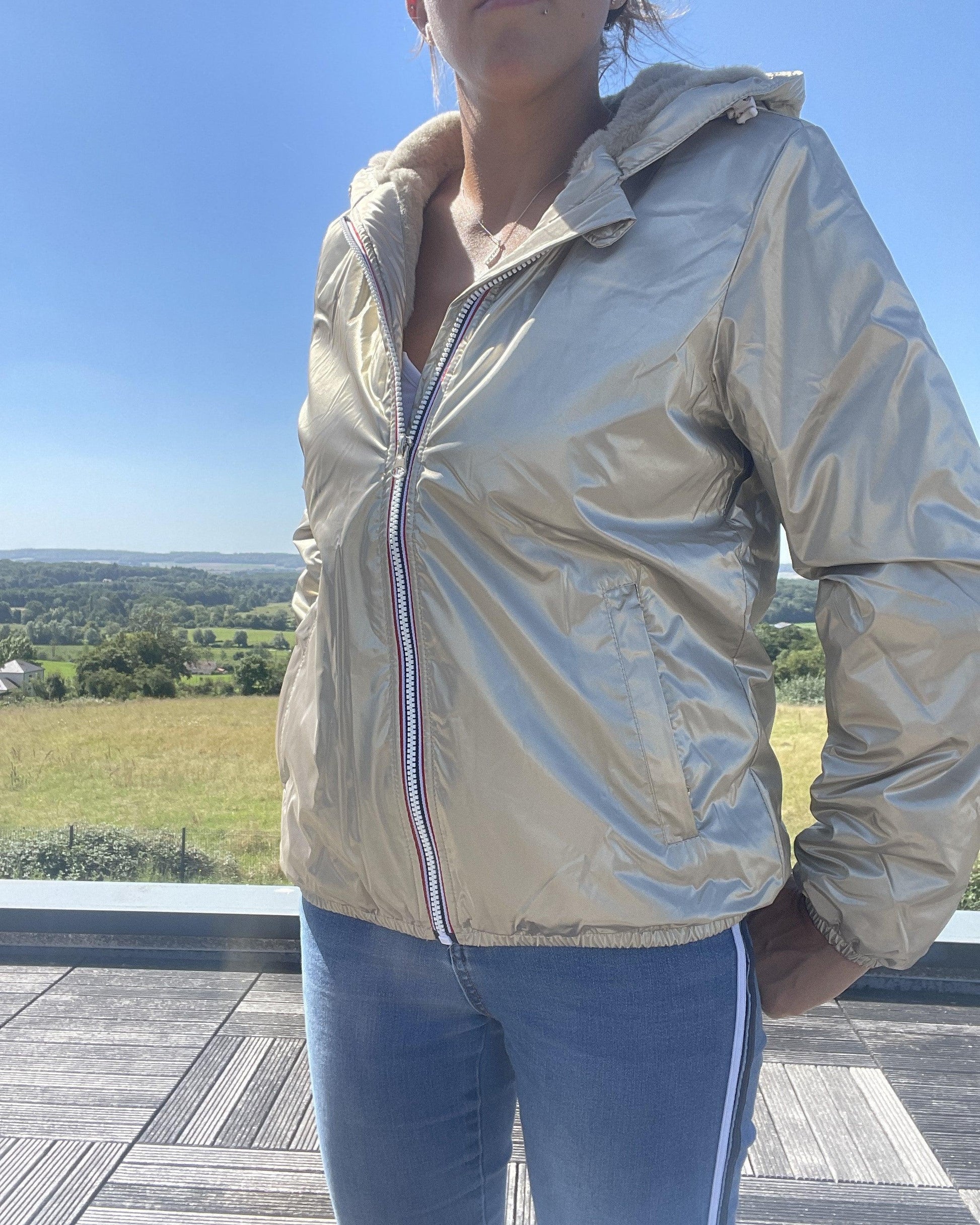 Woman wearing Laura Jo gold short waterproof jacket from Le Petit Placard outdoors