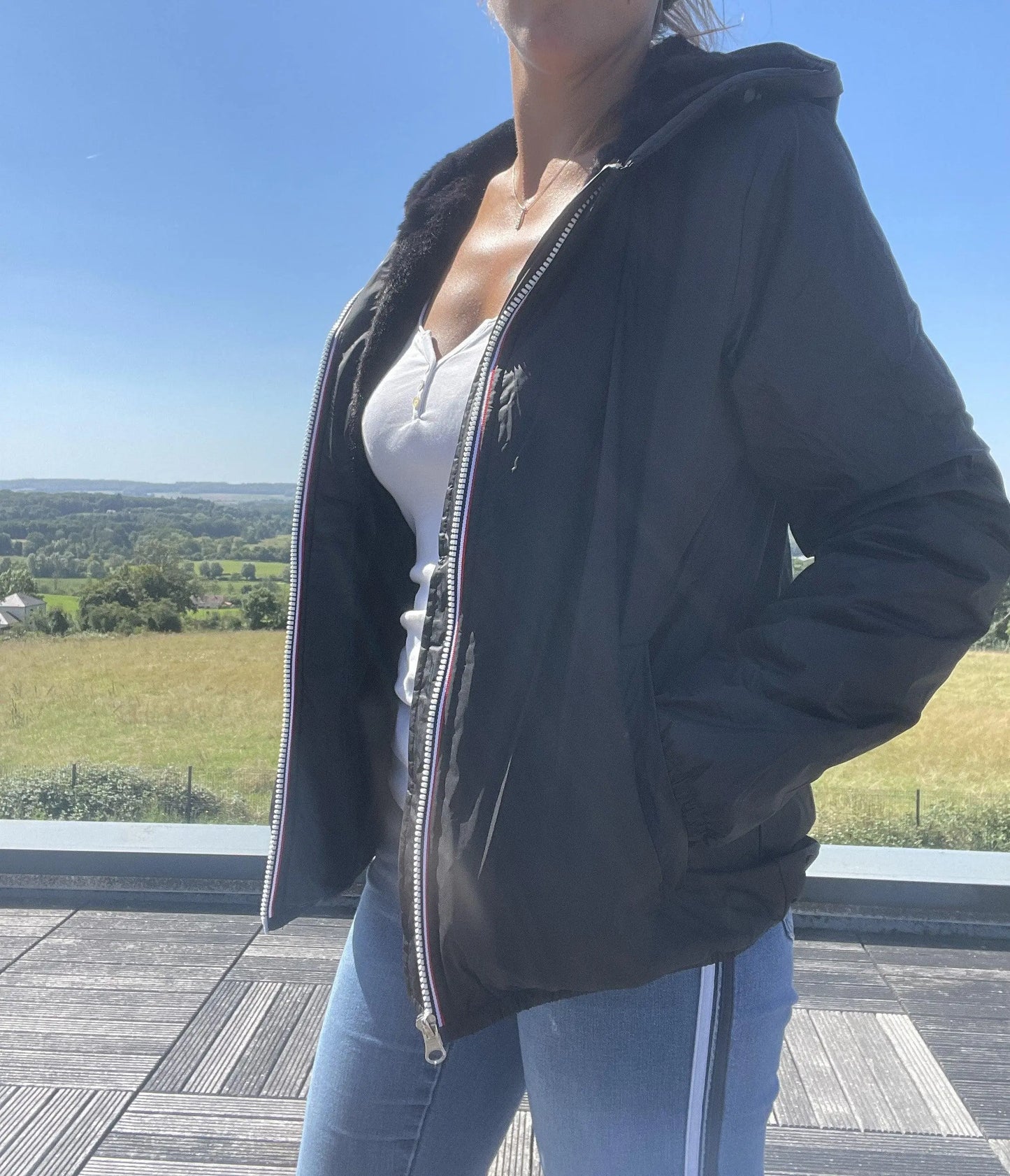 Woman wearing Laura Jo black rain jacket and jeans outdoors, Le Petit Placard fashion