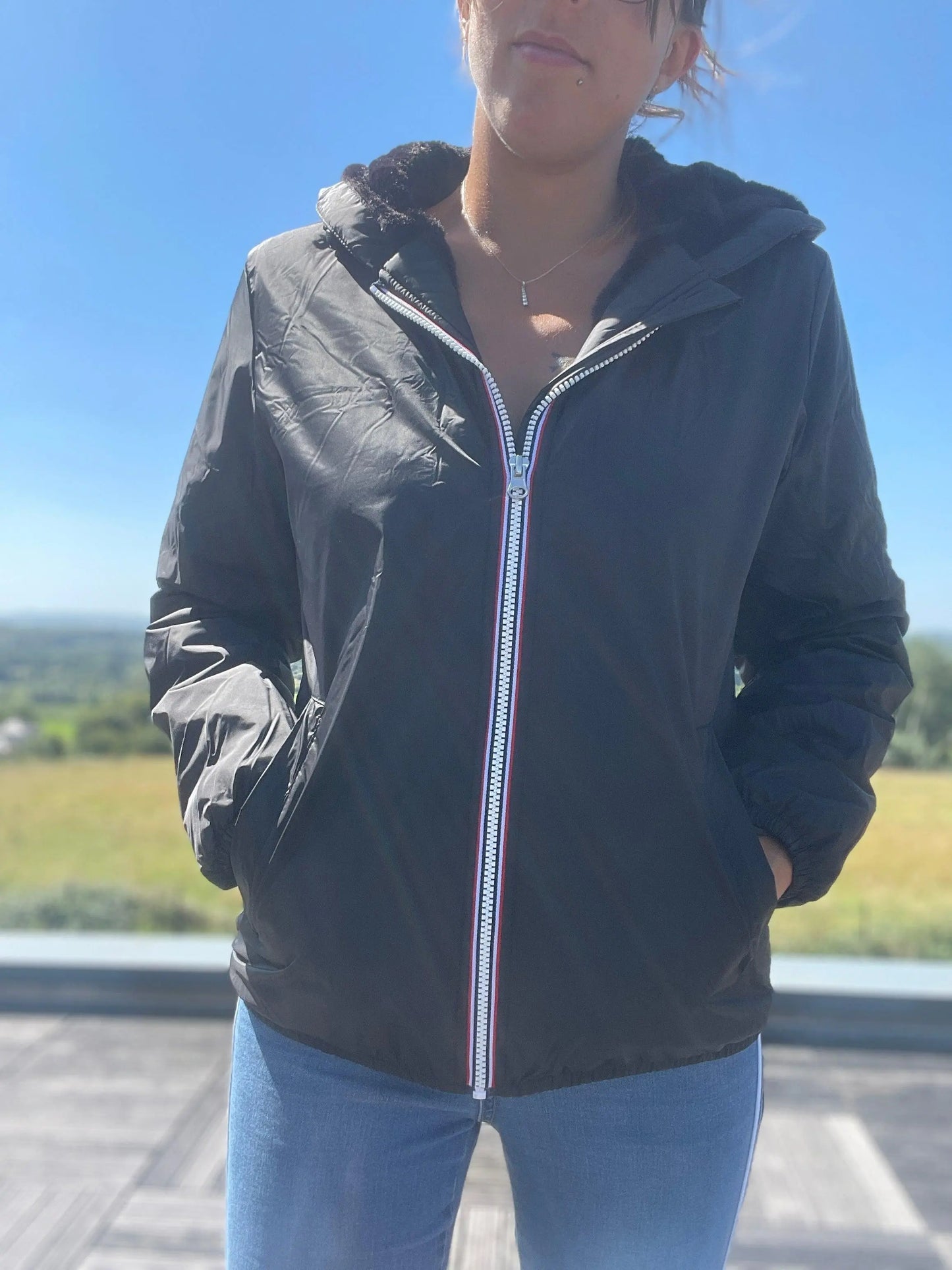 Woman wearing black Laura Jo waterproof short jacket with fur lining from Le Petit Placard