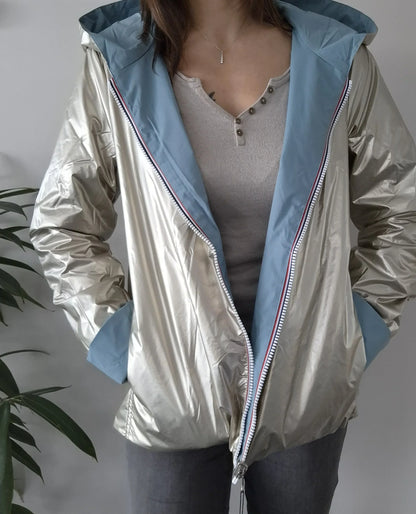 Manteau réversible court bleu ciel et doré Laura Jo porté ouvert, face dorée brillante visible avec capuche bleue