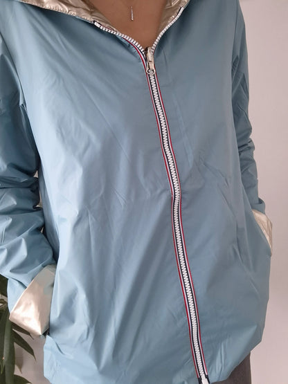 Manteau réversible court bleu ciel et doré Laura Jo avec fermeture éclair tricolore, porté par une femme
