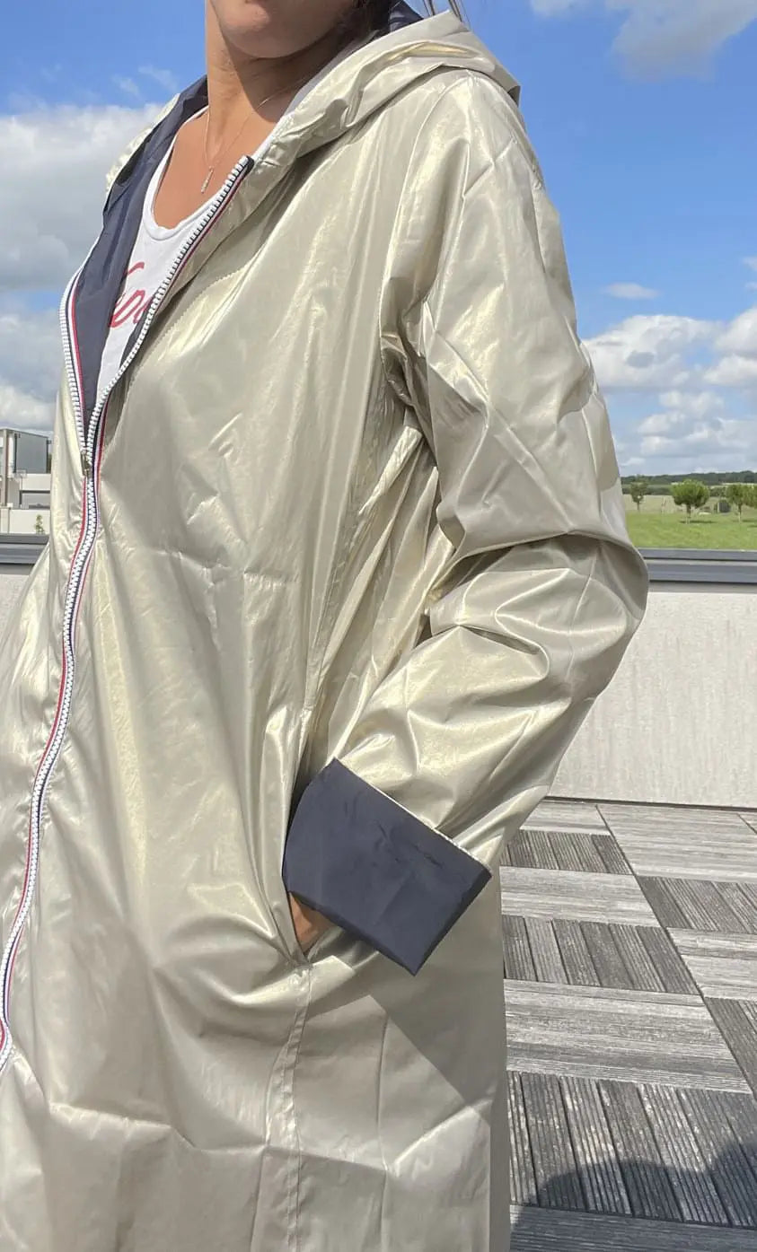 Manteau imperméable réversible Laura Jo, long bleu marine et doré, avec capuche et fermeture à boutons.