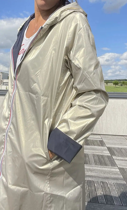 Manteau imperméable réversible Laura Jo, long bleu marine et doré, avec capuche et fermeture à boutons.