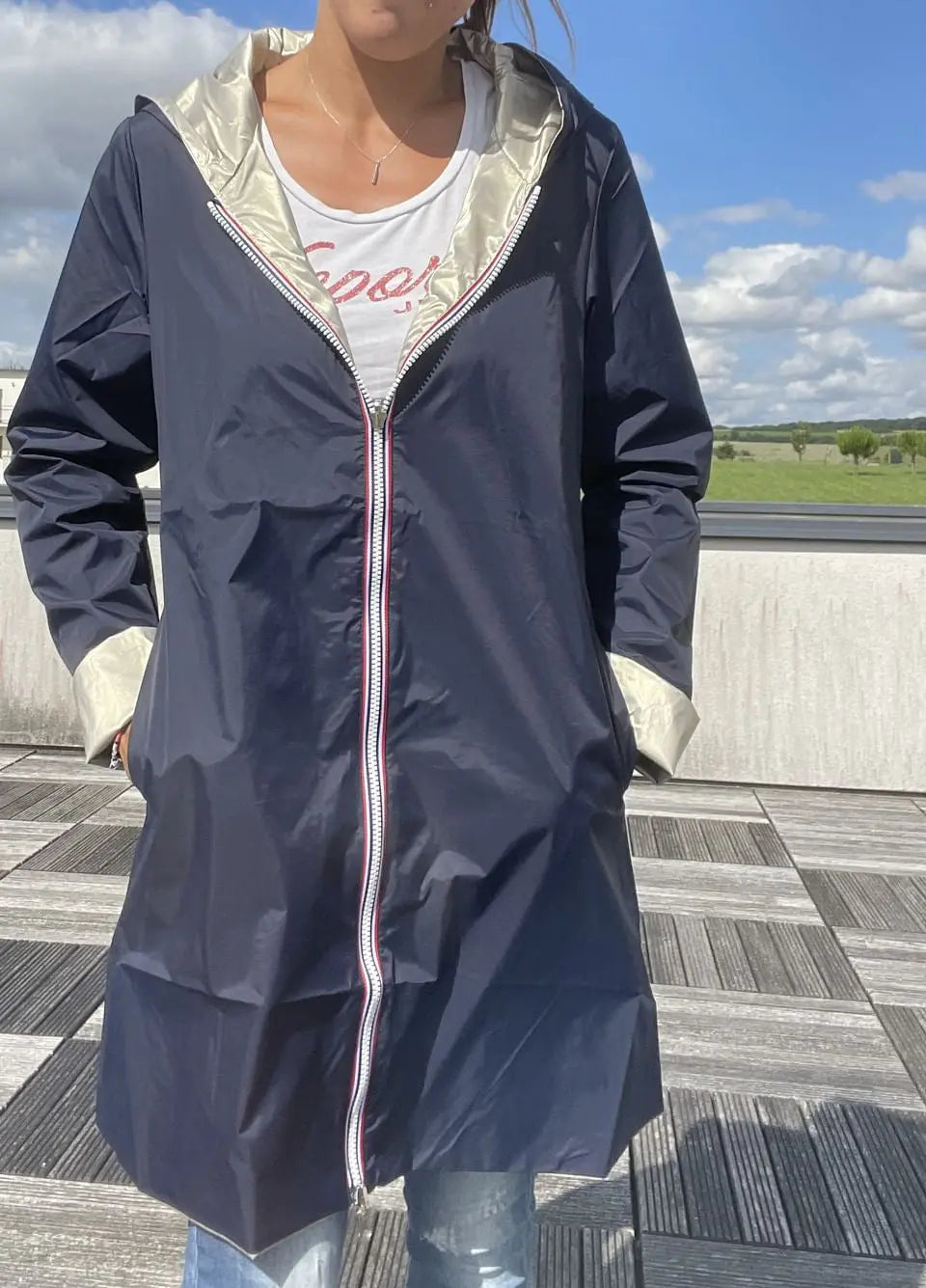 Manteau imperméable réversible Laura Jo bleu marine et doré, long avec capuche, tissu imperméable et finition élégante.