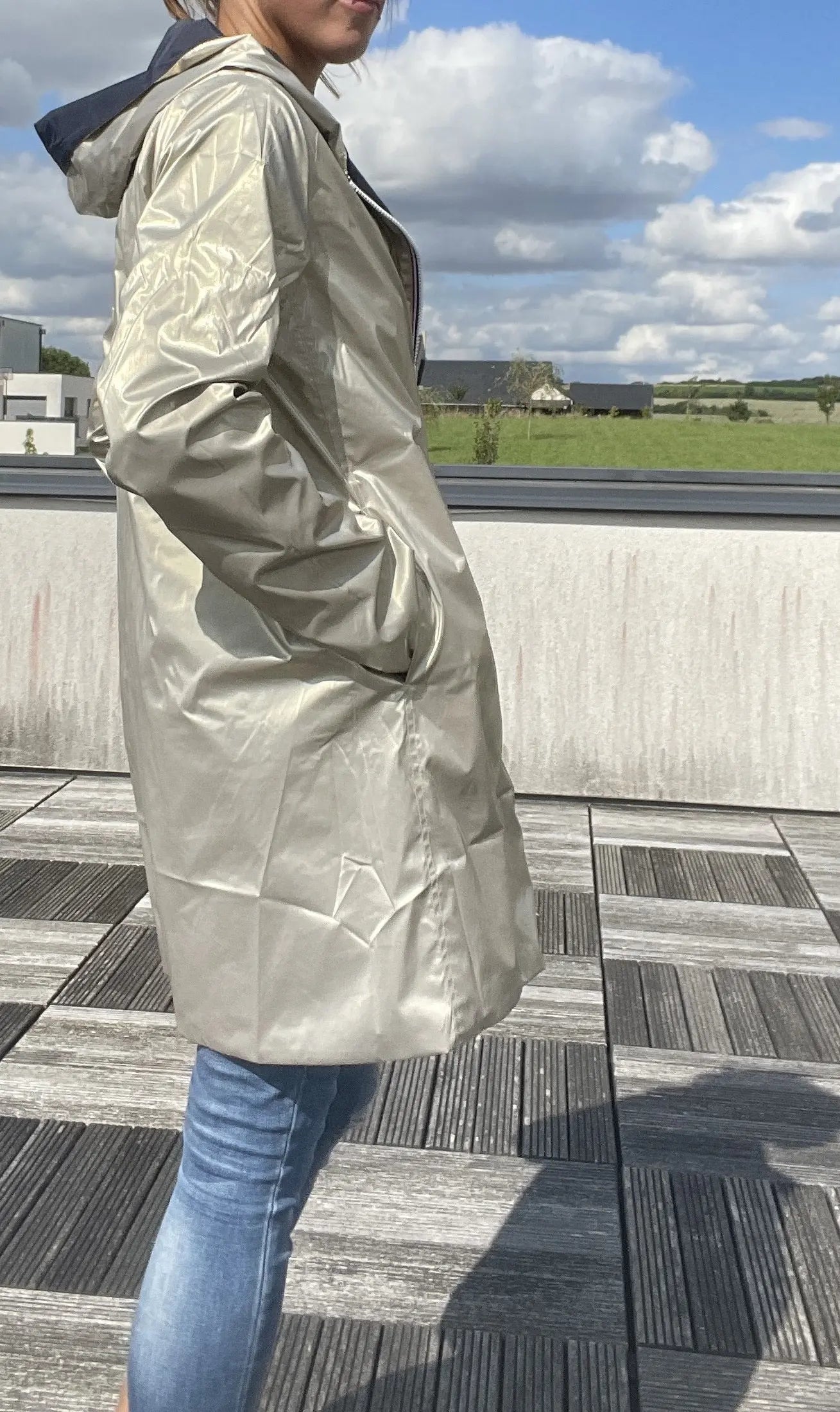 Manteau imperméable réversible long Laura Jo en bleu marine et doré, tissu imperméable avec capuche et fermeture à boutons.