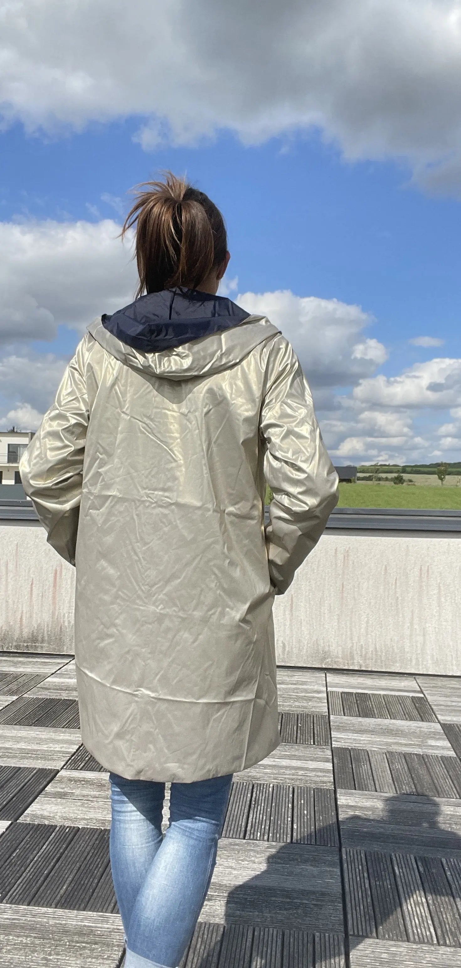 Imperméable réversible Laura Jo long bleu marine et doré, vue de face avec capuche et fermeture éclair.