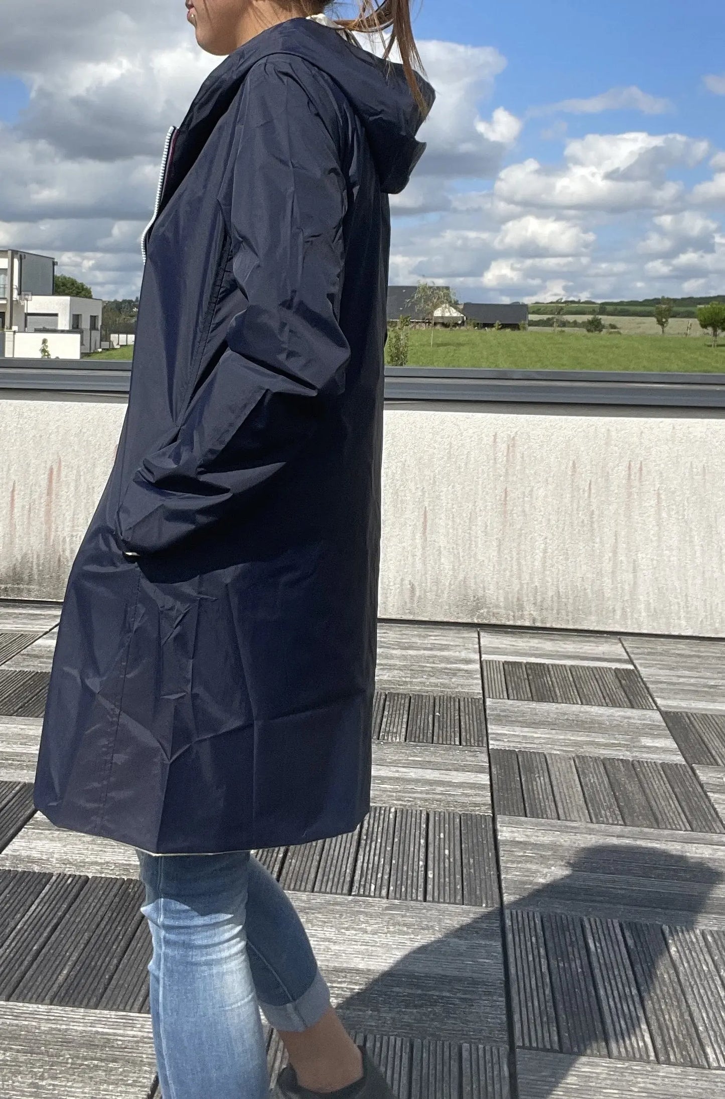 Manteau imperméable réversible Laura Jo, long bleu marine et doré, visible avec détails du tissu et de la coupe.