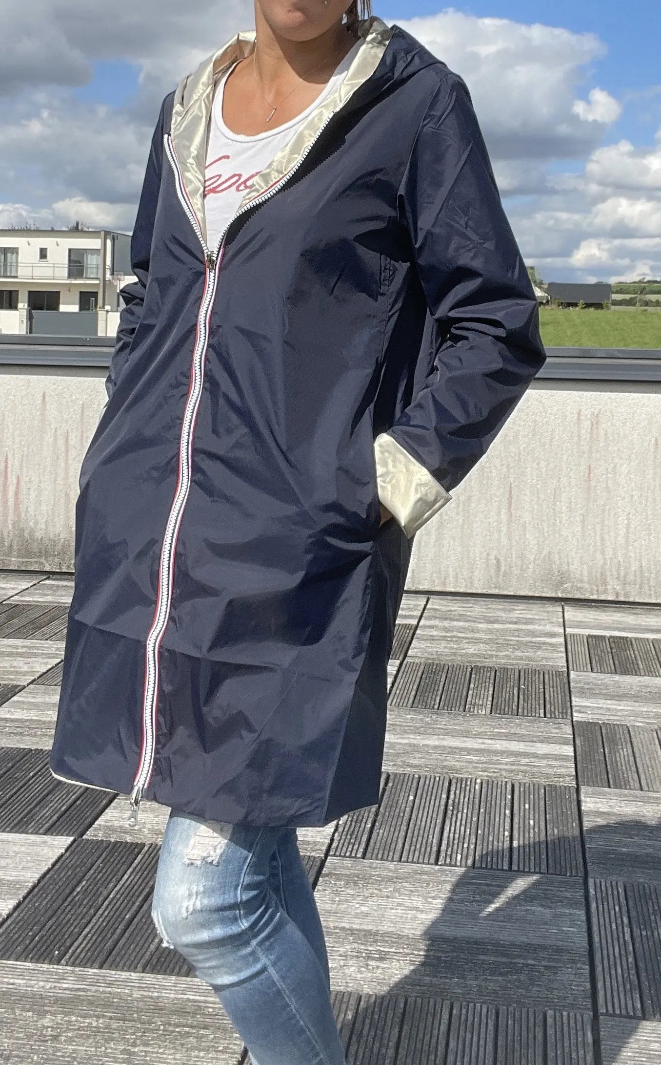Imperméable réversible long Laura Jo bleu marine et doré, manteau élégant avec capuche, porté sur une personne.