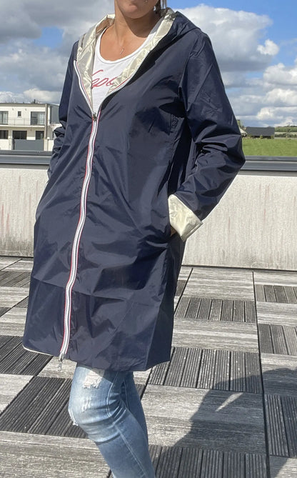 Imperméable réversible long Laura Jo bleu marine et doré, manteau élégant avec capuche, porté sur une personne.