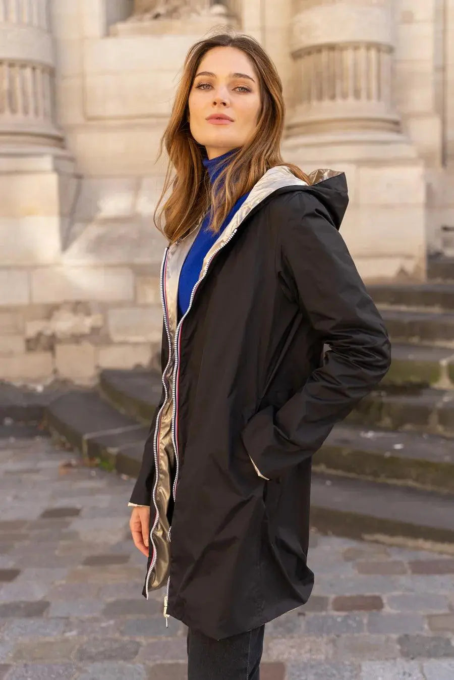 Imperméable réversible long noir et doré Laura Jo avec capuche, sans garnissage, porté en mode casual.