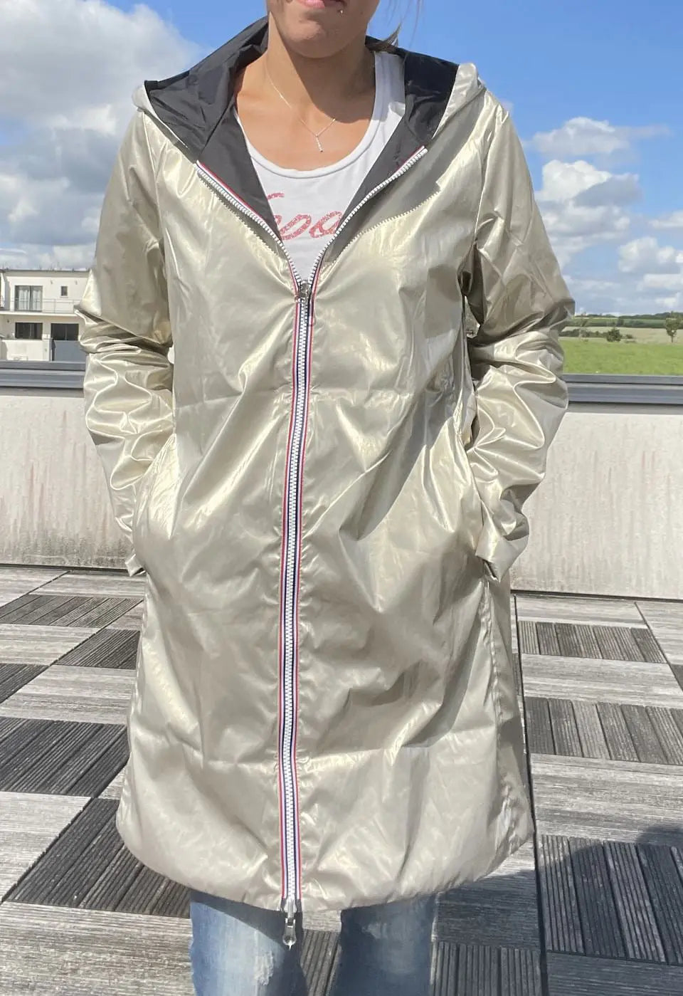 Imperméable long réversible noir et doré Laura Jo avec capuche, sans garnissage ouate, porté en style décontracté.