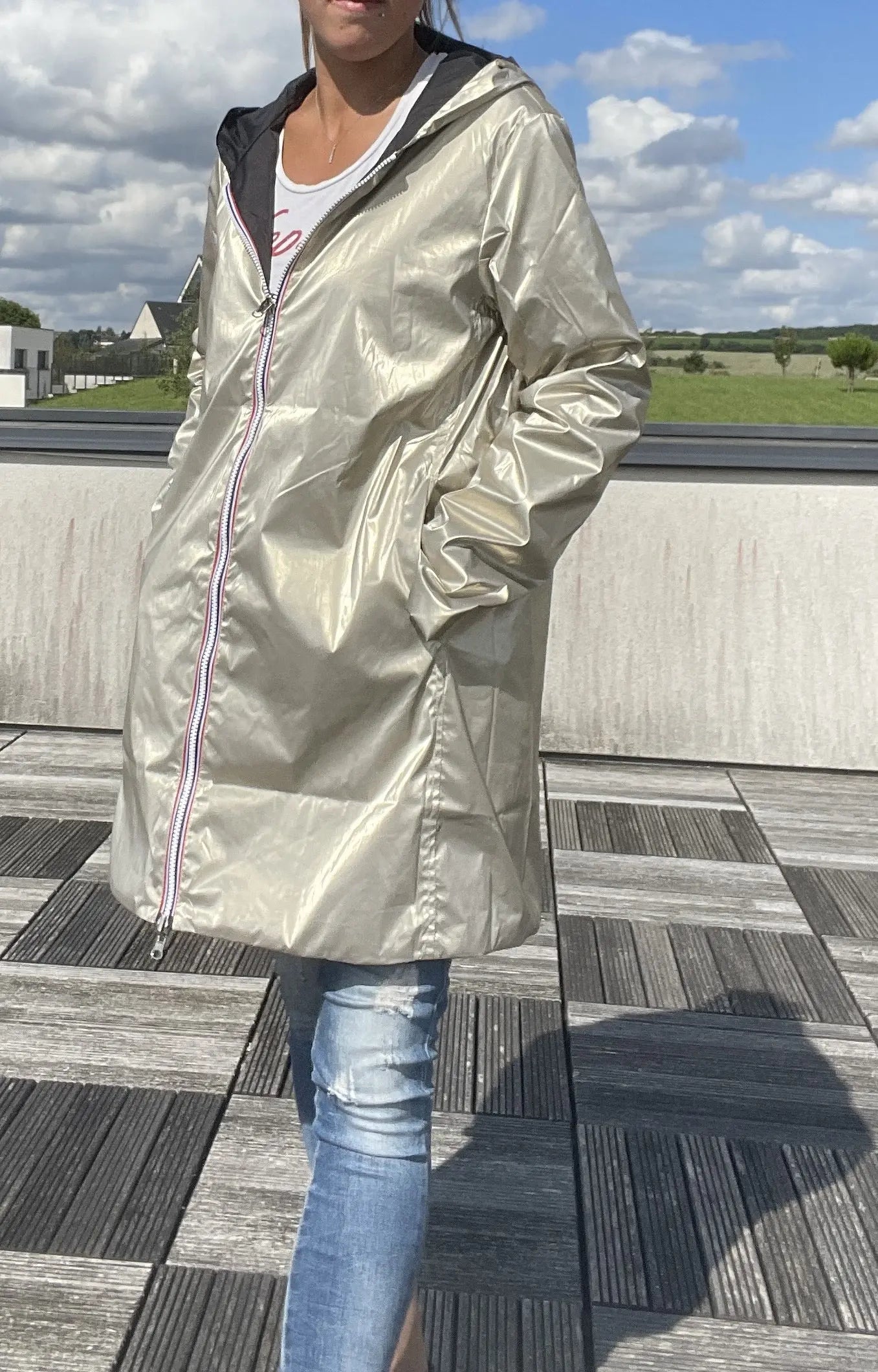 Manteau imperméable réversible long noir et doré à capuche de la marque Laura Jo, visible avec détails colorés et capuche ajustable.