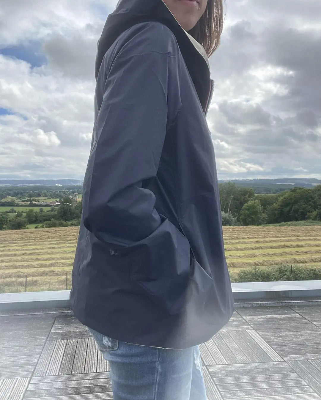 Imperméable réversible court Laura Jo bleu marine et doré, manteau mi-saison léger, avec capuche, porté en extérieur.