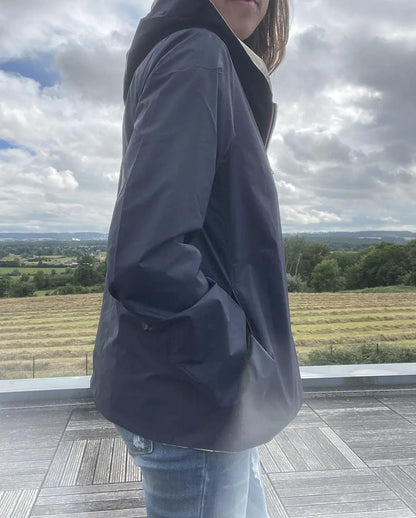 Imperméable réversible court Laura Jo bleu marine et doré, manteau mi-saison léger, avec capuche, porté en extérieur.