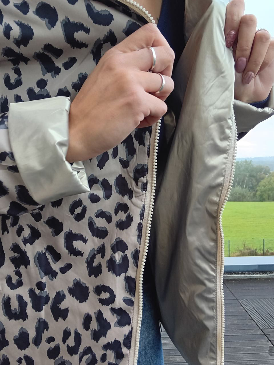 Gros plan sur une veste imperméable réversible beige, ouverte sur l’intérieur, avec zip visible et motif léopard sur la couche extérieure. Laura Jo - Imperméable réversible court garnissage ouate mi-saison doré / léopard zip uni - Curvy.