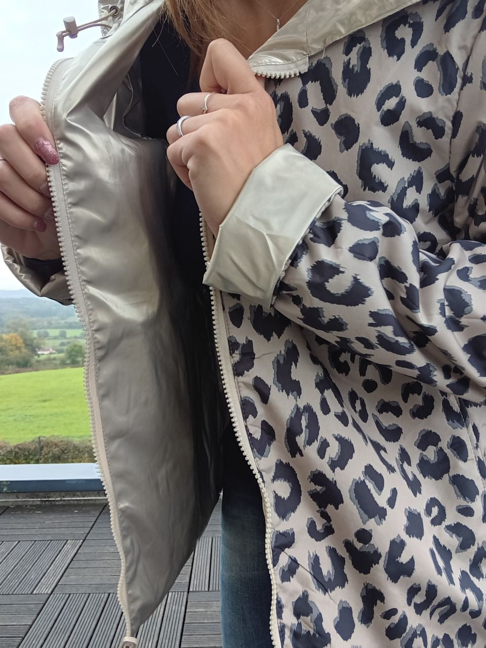 Imperméable réversible court avec motif léopard gris et beige, zippé, garnissage en ouate; personne montrant l’intérieur du manteau. Laura Jo - Curvy.