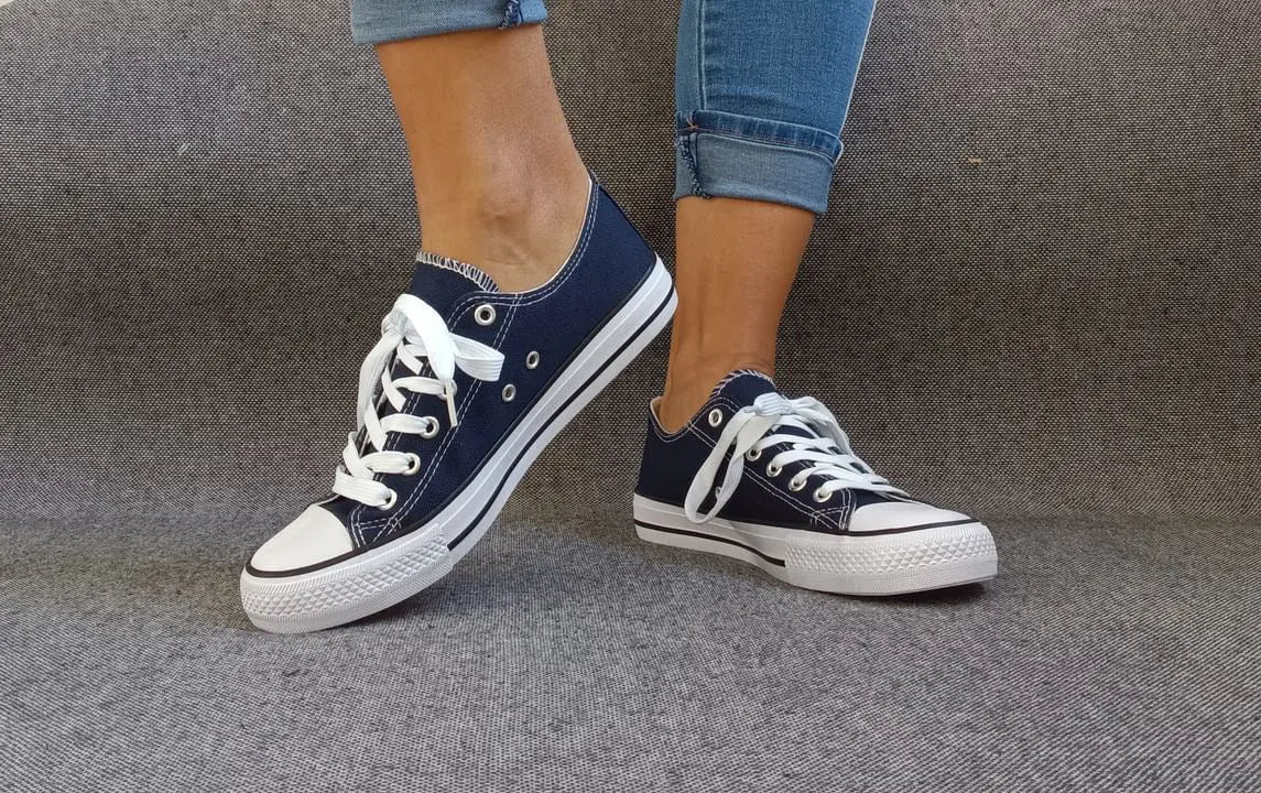 Baskets basses bleu marine et blanc type converse portées avec un jean, lacets blancs et semelle blanche