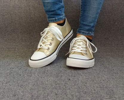 Baskets Converse gold portées avec jean brut