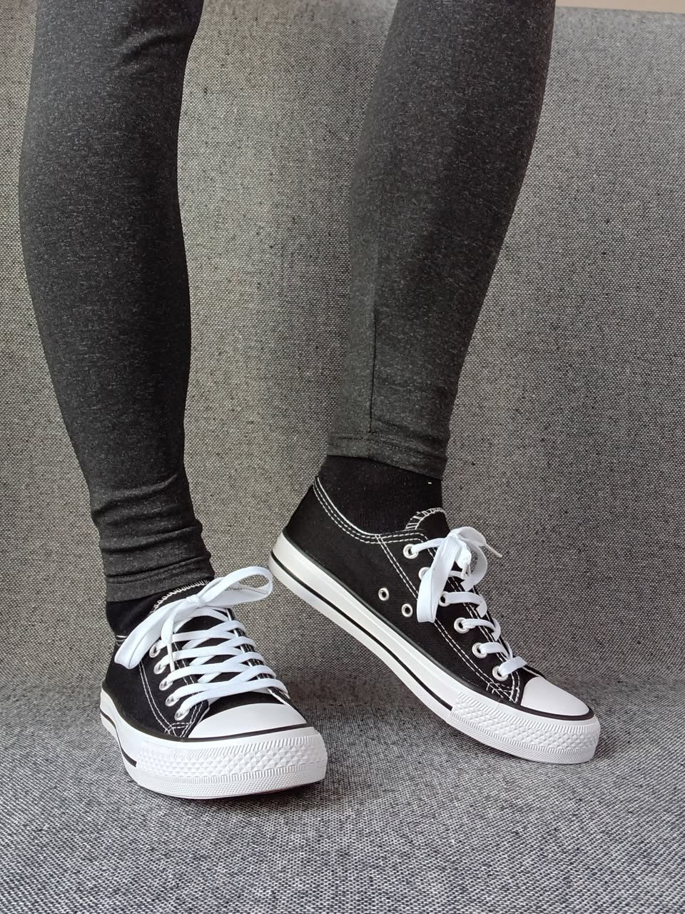 Baskets basses noir et blanc femme style Converse bicolore portées avec un legging gris anthracite
