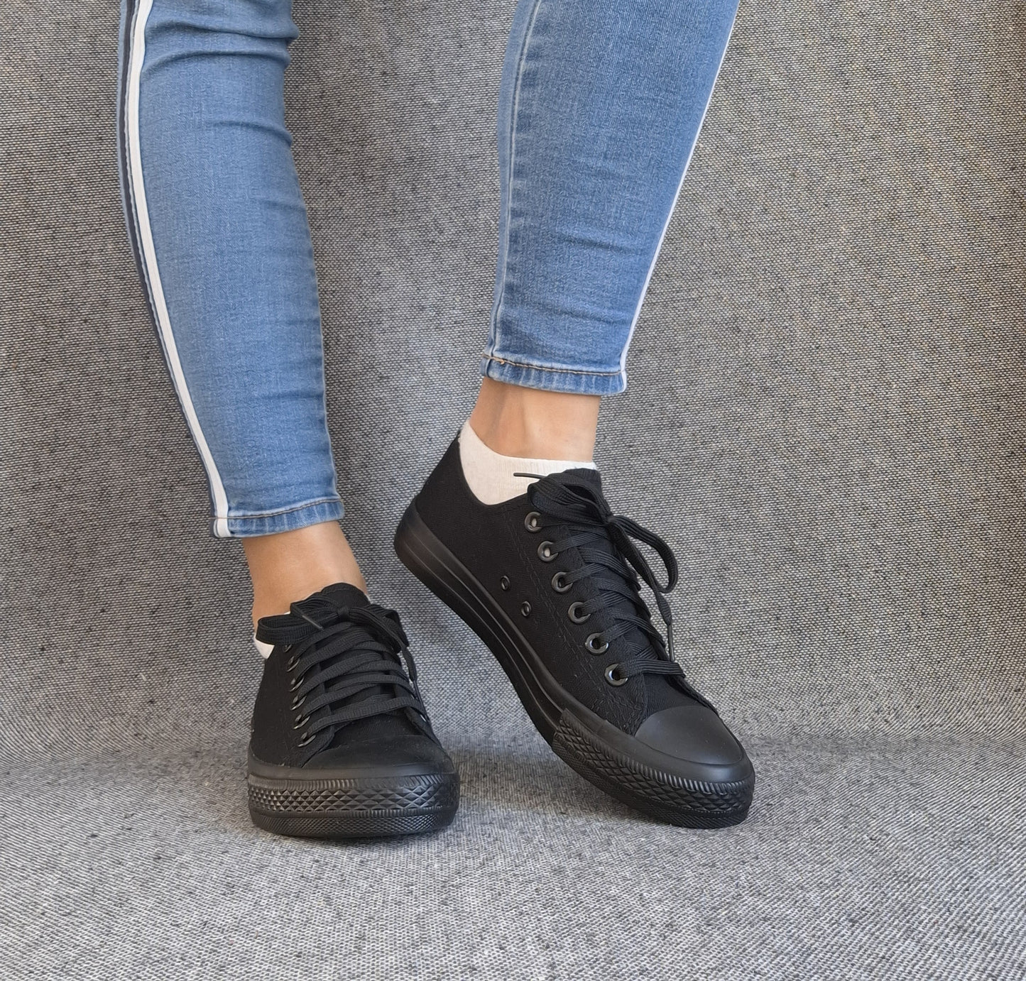 Baskets basses noir femme style Converse classique portées avec un jean bleu, look casual tendance