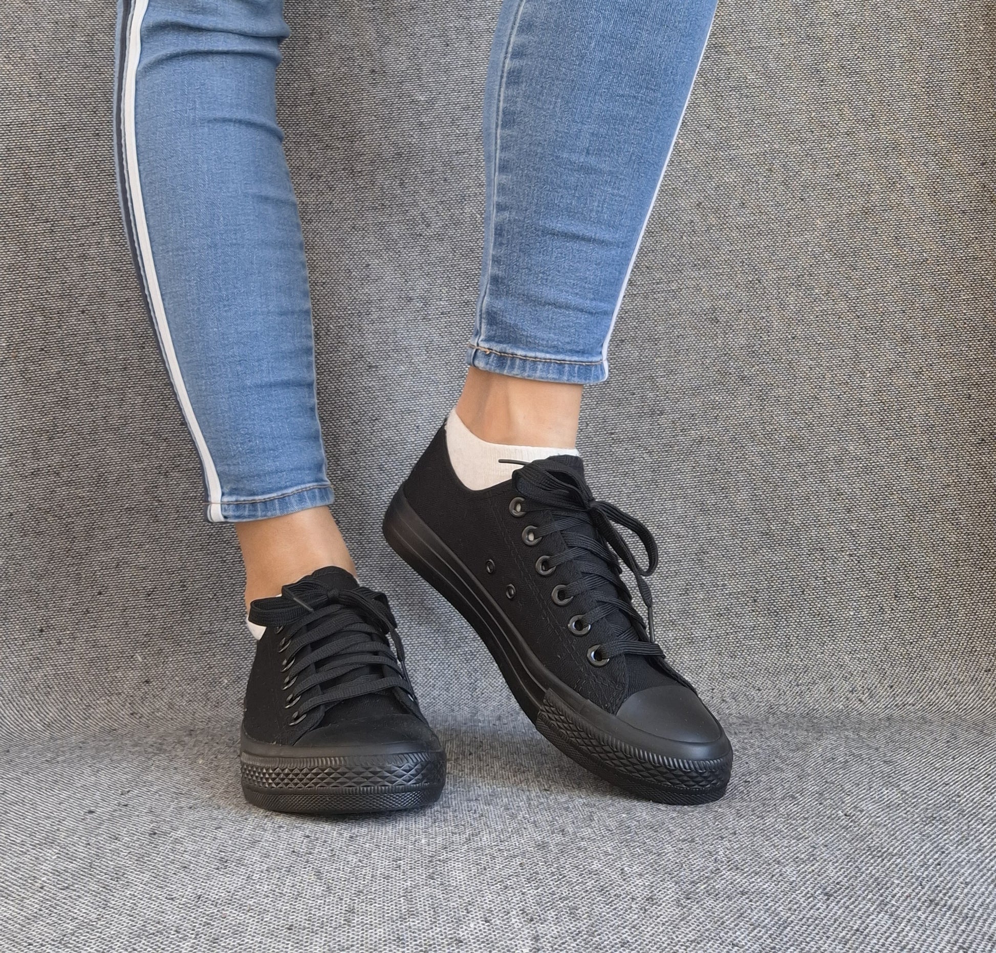 Baskets basses noir femme style Converse classique portées avec un jean bleu, look casual tendance