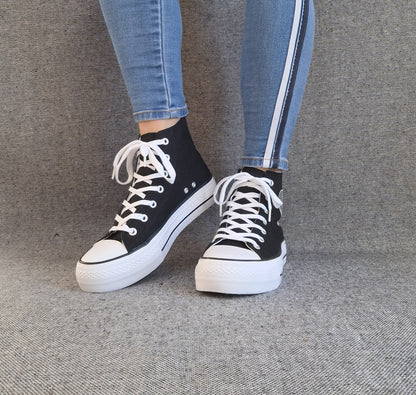 Baskets hautes Amour femme noires style Converse, lacets blancs et semelle plateforme, portées avec un jean slim
