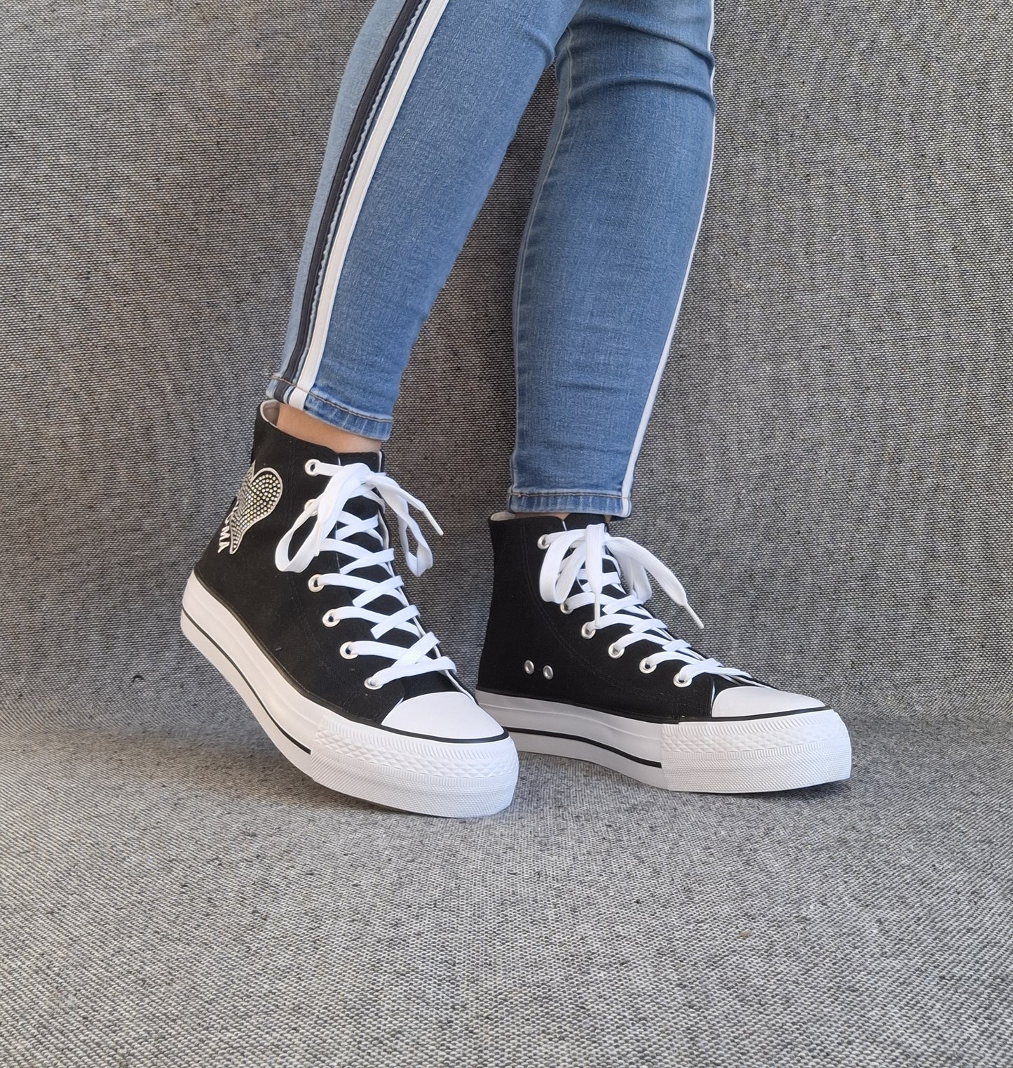 Baskets hautes Amour femme noires montantes style Converse, lacets blancs et patch ailes, portées avec jean slim