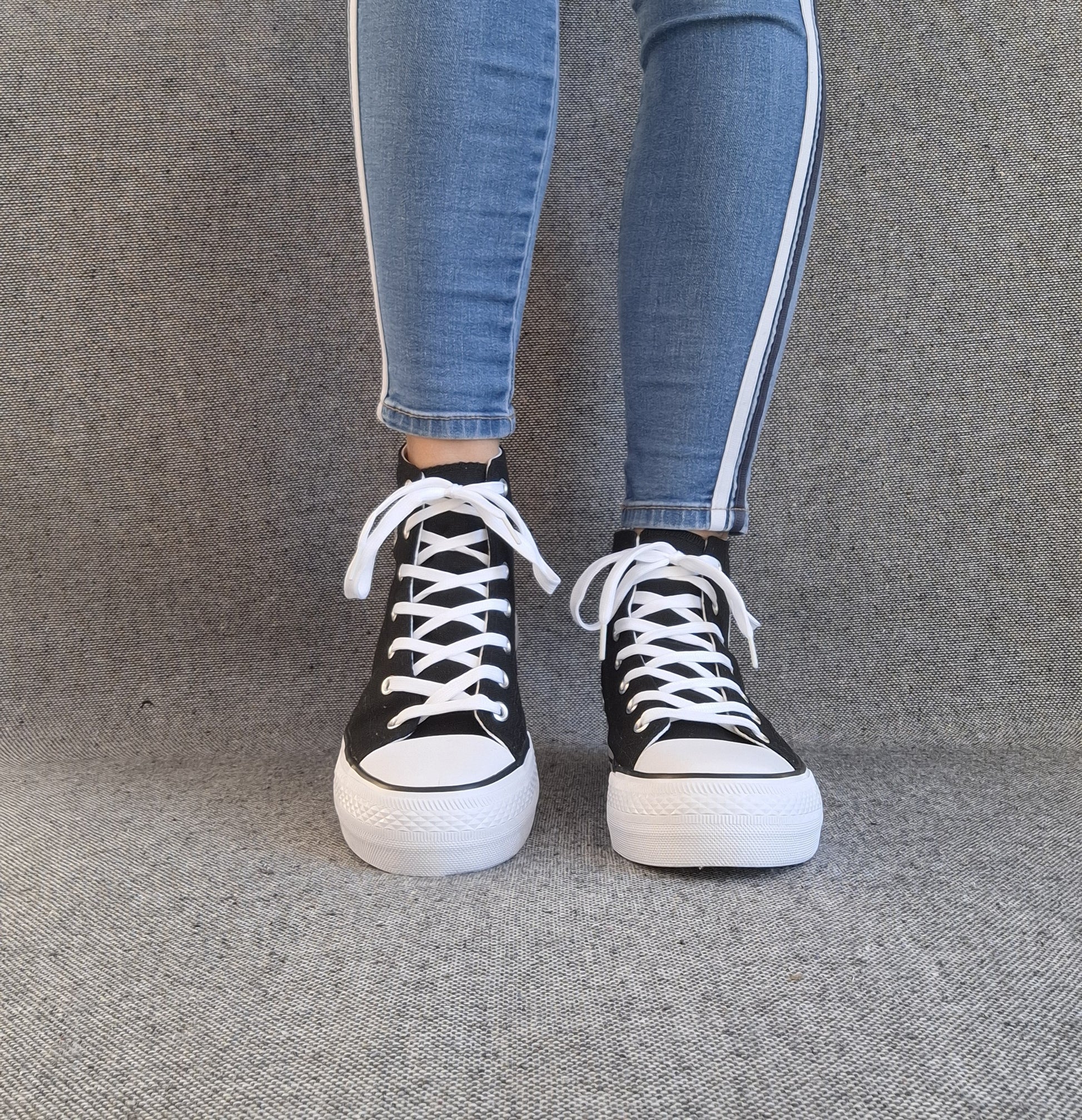 Baskets hautes Amour femme noires style Converse, lacets blancs et semelle plateforme, portées avec un jean slim
