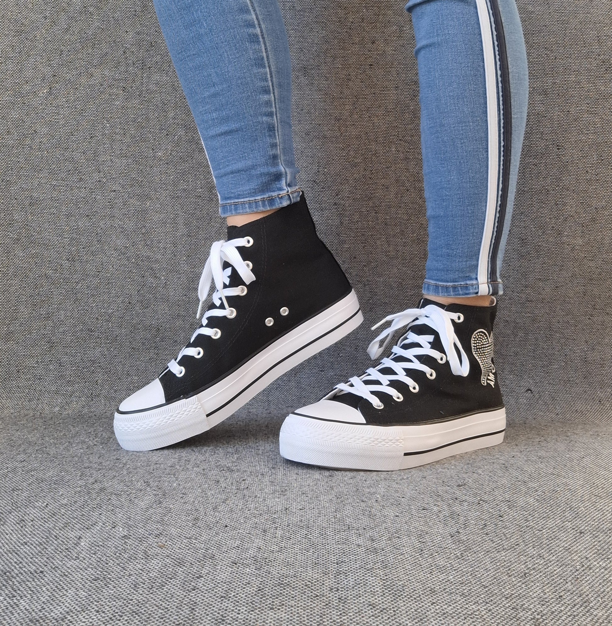 Baskets hautes montantes Amour femme noires style Converse avec inscription et lacets blancs portées avec un jean