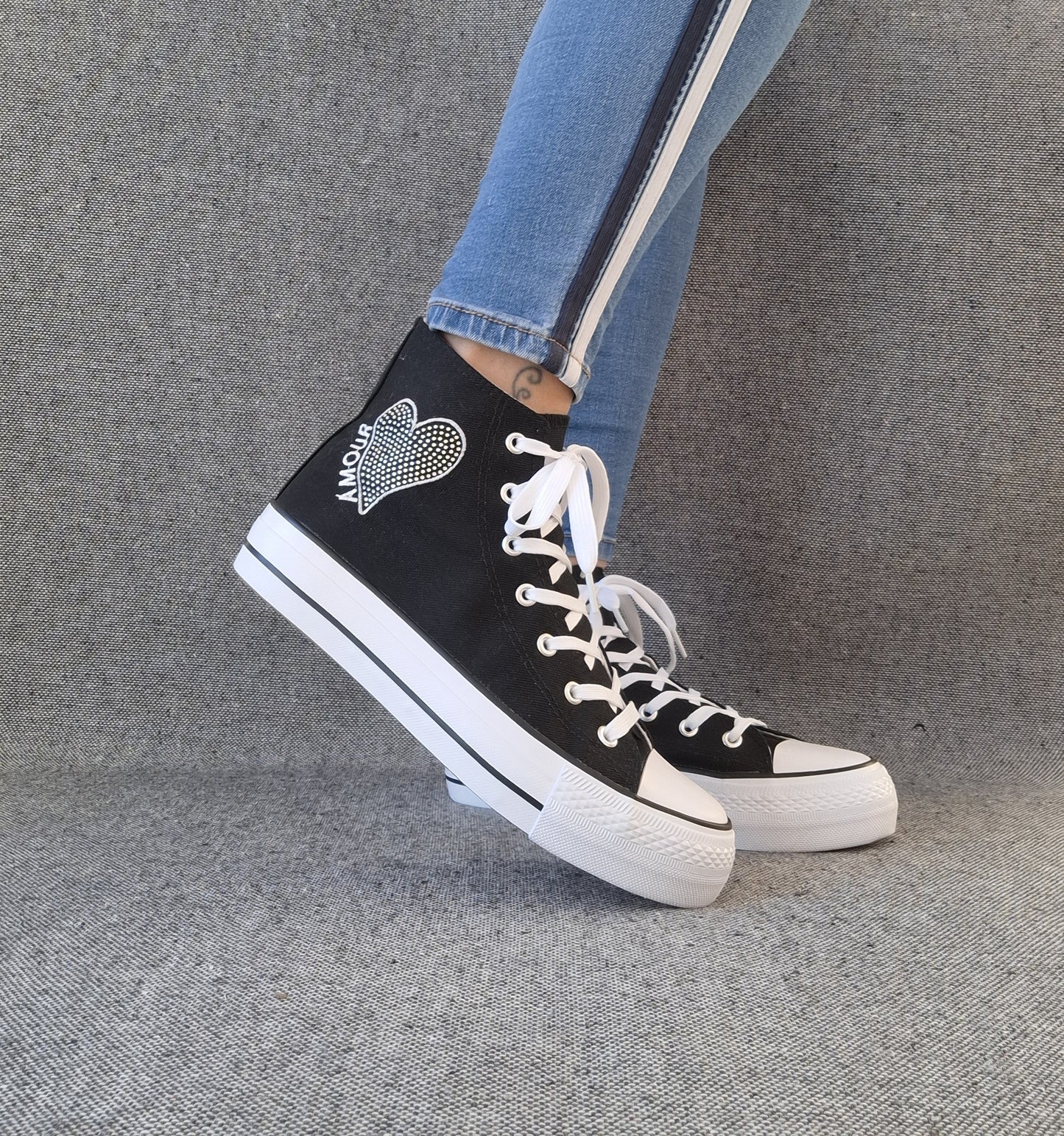 Baskets hautes Amour femme noires style Converse avec inscription et cœur, portées avec un jean