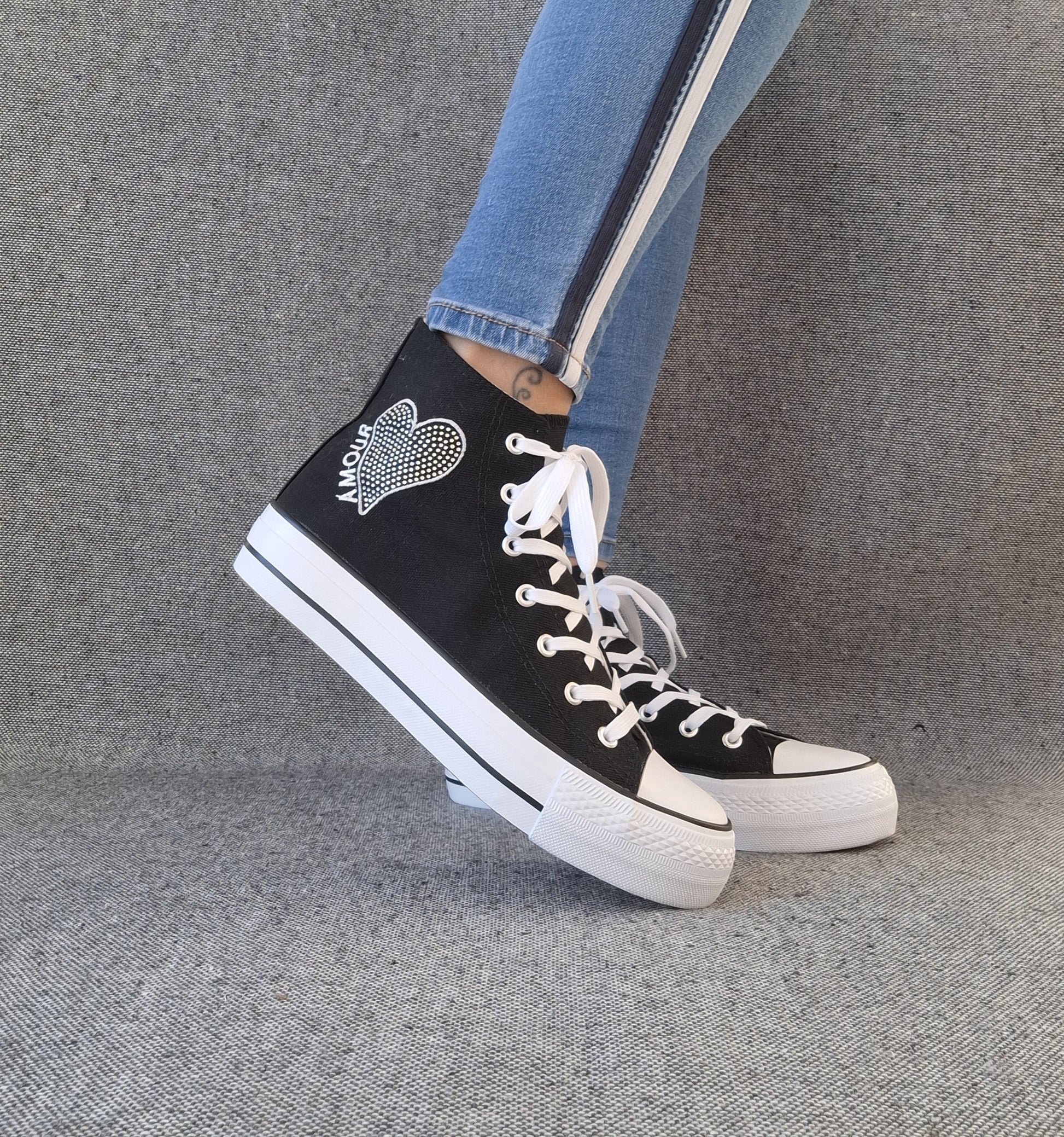 Baskets hautes Amour femme noires style Converse avec inscription et cœur, portées avec un jean