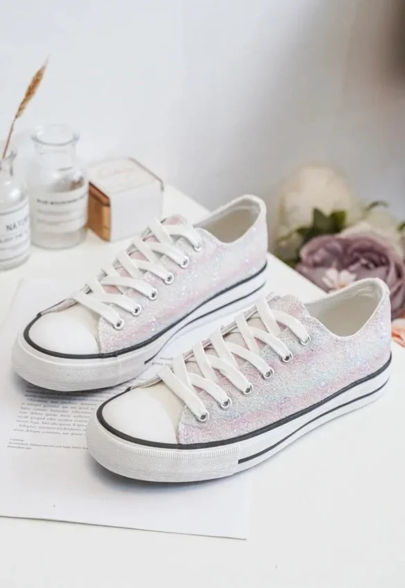 Chaussures baskets basses en tissu dentelé irisé multicolore style Converse, lacets blancs et semelle blanche avec bord noir.