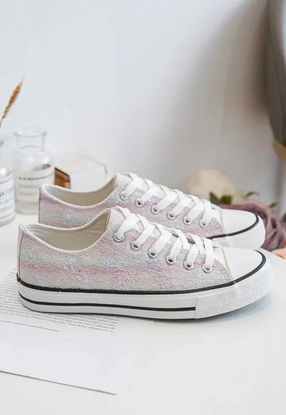 Chaussures baskets basses en tissu dentelé irisées multicolores style Converse avec semelle blanche et lacets blancs.