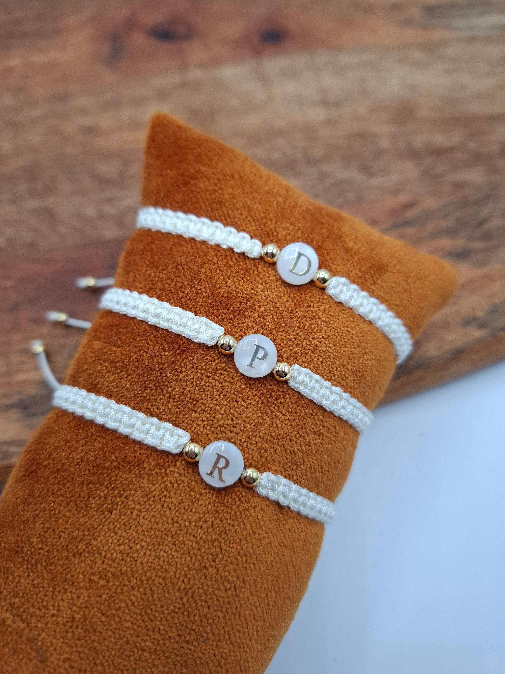 White braided initial bracelets with gold beads on velvet display, Le Petit Placard accessories