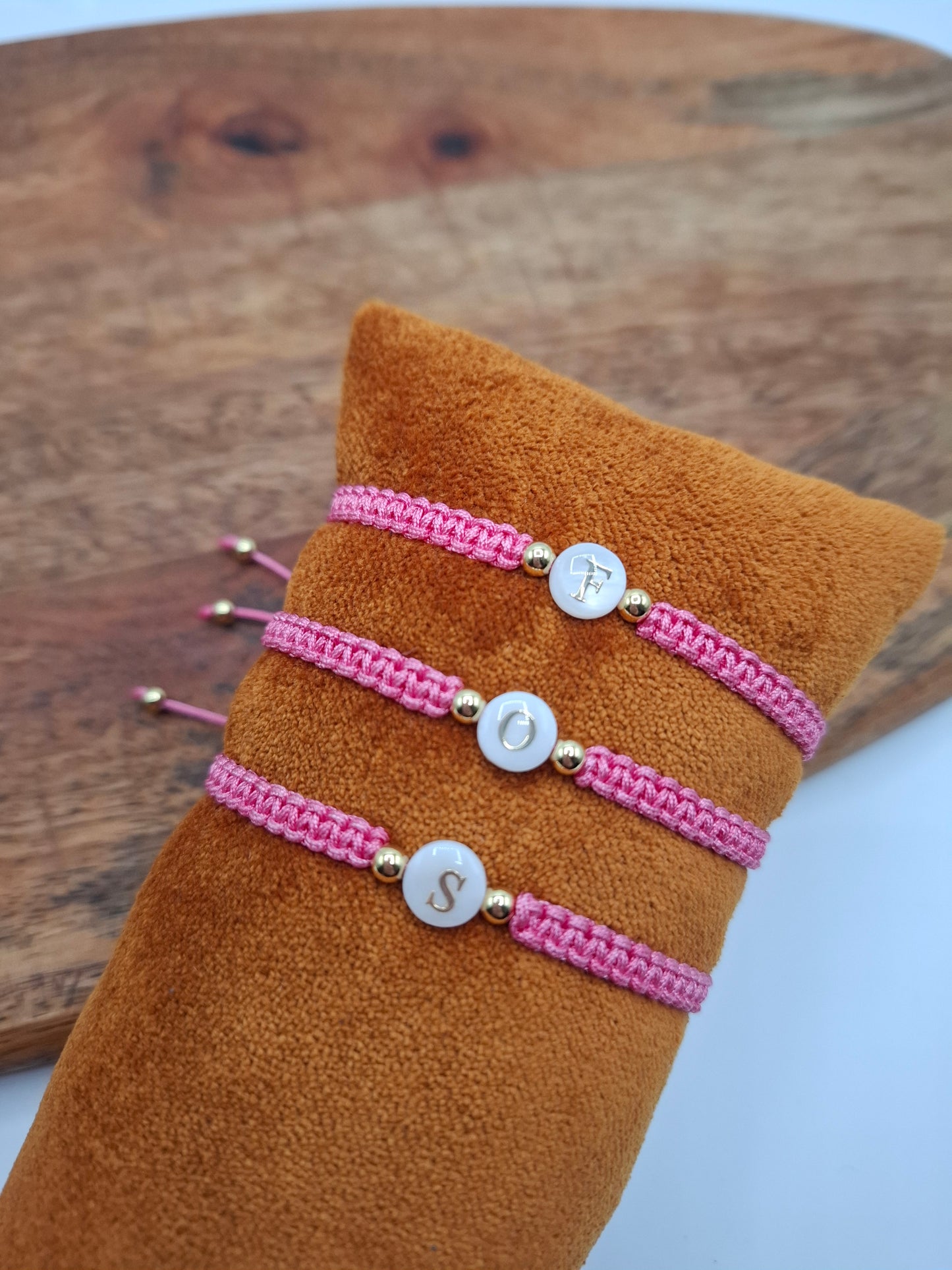 Pink braided bracelets with gold accents and letter charms, trendy accessories at Le Petit Placard