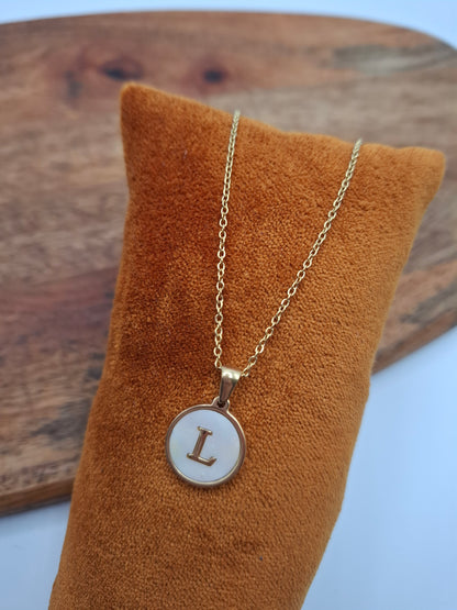 Gold necklace with round L initial pendant displayed on brown velvet, Le Petit Placard accessory