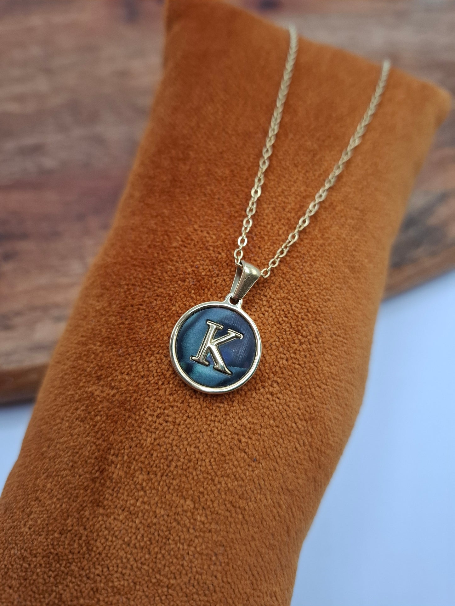 Gold necklace with blue letter K pendant on display, Le Petit Placard jewelry accessory