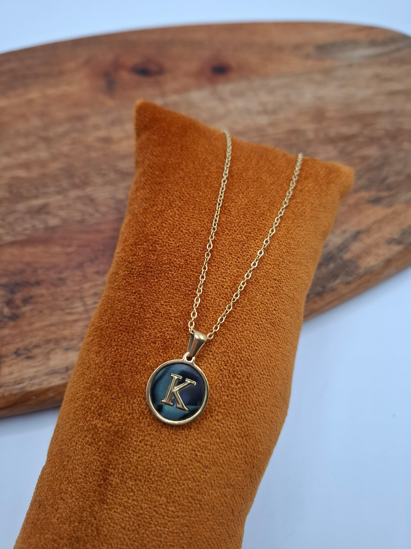 Gold necklace with blue K pendant on display at Le Petit Placard, fashion accessories