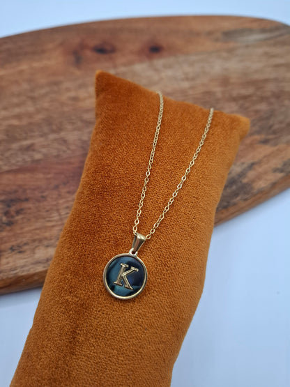 Gold necklace with blue K pendant on display at Le Petit Placard, fashion accessories
