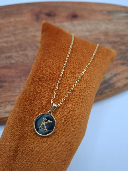 Gold necklace with blue letter K pendant on orange velvet display, Le Petit Placard jewelry
