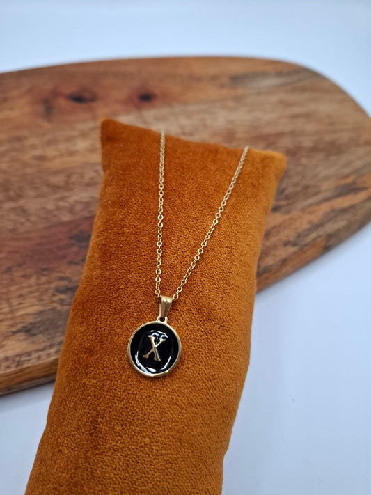 Gold initial X pendant necklace on a velvet display, Le Petit Placard jewelry accessory